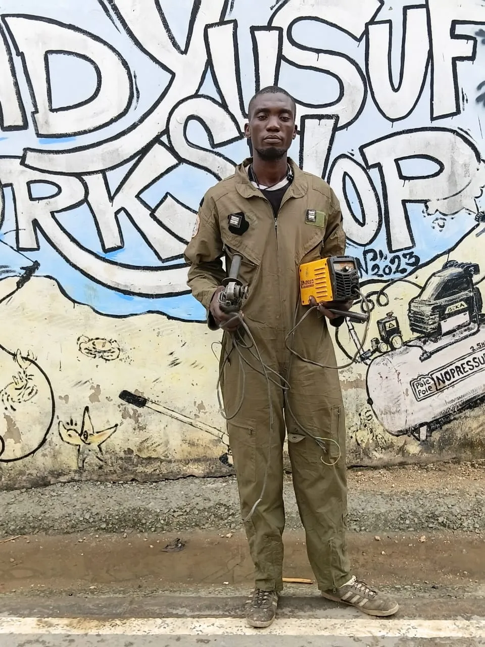 Beka standing with an angle grinder and welding machine
